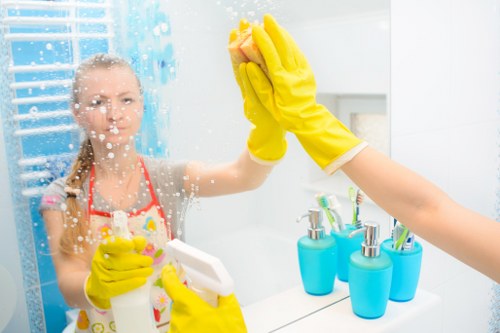 Brent office cleaners disinfecting high-touch surfaces in a busy workspace